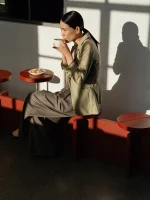 Woman drinking coffee in a sunlit cafe