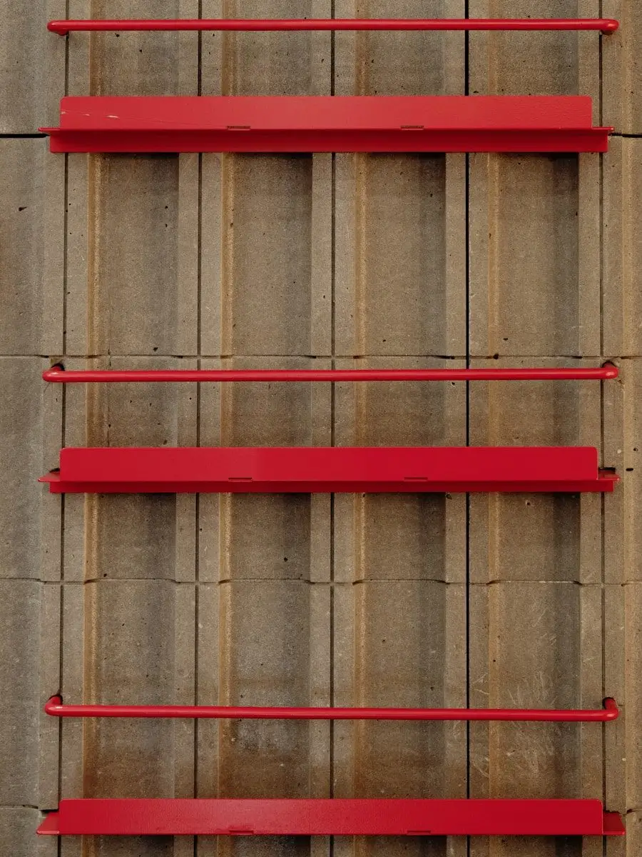 A red shelf on the side of a building